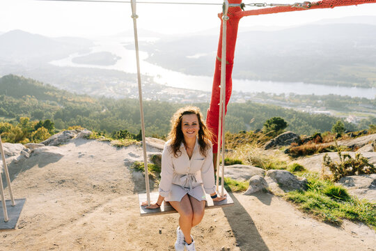 Young woman on a swing against a beautiful landscape