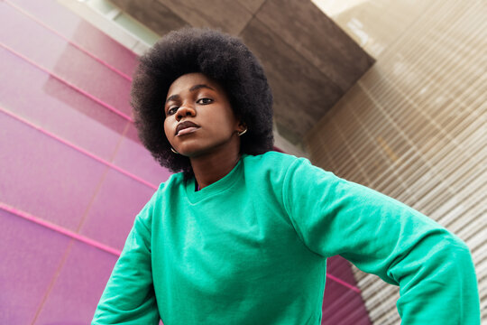 African young woman with afro hairstyle posing in urban background.