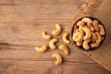 Pile of roasted cashew nut in bowl on the table background. Food concept