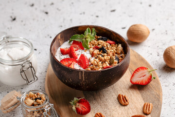 Portion of healthy granola with yogurt, strawberries and nuts