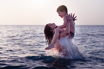 mom and son bathe in the sea happy on the water