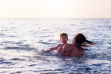 mom and son bathe in the sea happy on the water