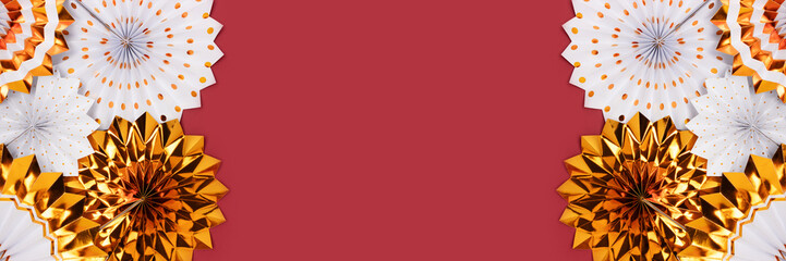 Banner with gold colored paper fans on a red background with place for text.