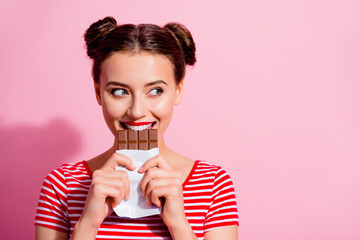 Picture of charming funny female break her diet plan eat yummy chocolate bar isolated on pink color...