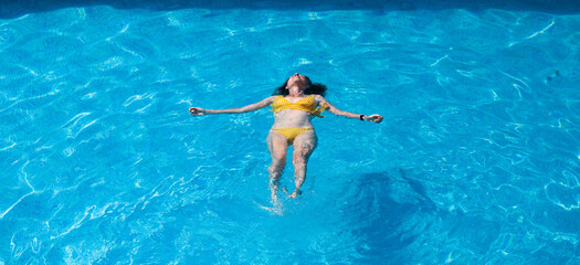 top view of woman floating in swimming pool