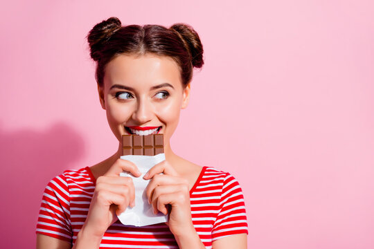 Picture of charming funny female break her diet plan eat yummy chocolate bar isolated on pink color background