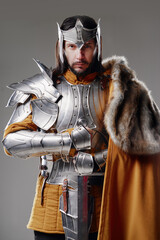The King. Handsome Medieval knight in armor holding sword.