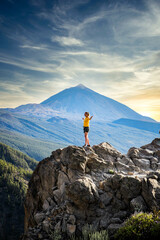 woman sitting on a rock El Teide volcano at sunset in background Tenerife  Canary islands
