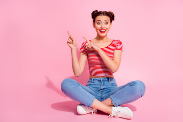 Photo of adorable pretty woman wear cropped t-shirt sitting legs crossed pointing empty space...