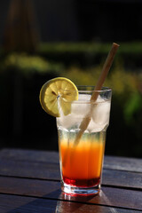Coctail with lemon, ice and bamboo reed straw made of natural materials, without chemicals and plastics with dark background with space for text. Ecological, environmentally free.