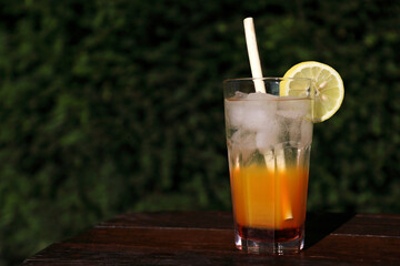 Coctail with lemon, ice and bamboo reed straw made of natural materials, without chemicals and plastics with dark background with space for text. Ecological, environmentally free.