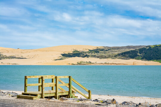 Wooden steps leading down to the sandy beach. Beautiful seaside landscape. Oponnoni, Northland, New Zealand