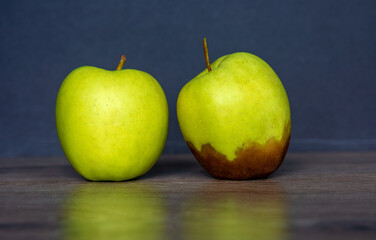 Fresh and rotten Apple. fruit with mold on wooden background	
 