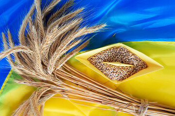 grain wheat and spikelets on a blue background. Ukrainian grain and problems of sea blockade of...