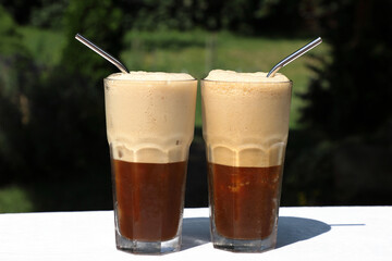 Two iced coffees in a glass with stainless drinking straws on a hot summer day. Completely plastic-free and do not contain microplastics. Concept without plastic.