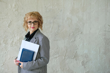 Adult girl in the jacket and glasses school or university teacher holding notepad. Business woman concept.