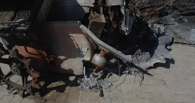 Tracking shot of Russian airborne combat vehicle destroyed by Ukrainian artillery shelling, exhibited on city street for demonstration. Detail of rusty burnt military weapon BMD