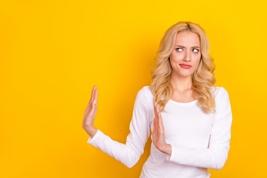Photo of unhappy strict young woman wear white shirt asking arms stop empty space isolated yellow color background