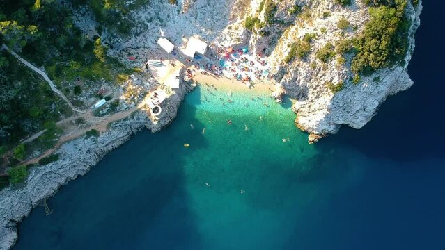 Tourists Swimming At Turquoise Sea Water On Klancac Beach In Brsec, Croatia. - aerial