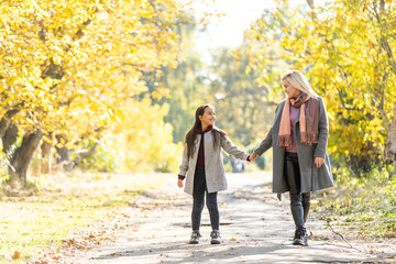 Obraz premium mother with her daughter in autumnal alley