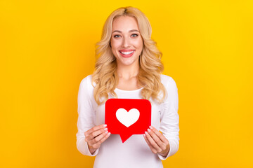 Photo of cute millennial blond lady hold like wear trend cloth isolated on yellow color background