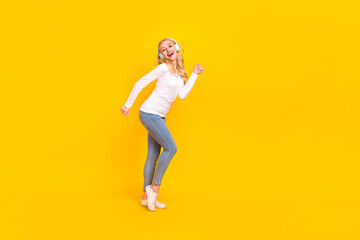 Fototapeta na wymiar Full size photo of cool young blond lady dance wear shirt jeans sneakers isolated on yellow color background
