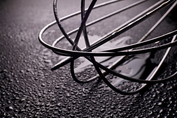 close-up metal whisk tool with water drops