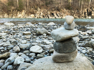 Fototapeta na wymiar pyramid made of stones on the bank of a mountain river