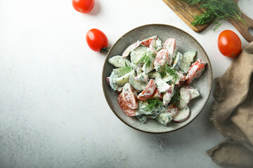 Homemade vegetable salad with tomato, cucumber and sour cream