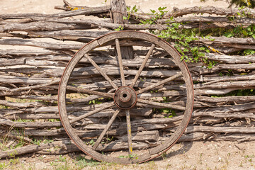 Fototapeta na wymiar Old wagon wheel on the wooden fence