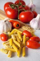 Pasta Whole Grain Spaghetti Penne Tomatoes Garlic Pepper Vegetable on Gray background Italian Food Vertical