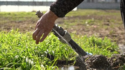 Shot of fountain pouring even though closed, shot with selective focus on green field background. Distorted fountain image.