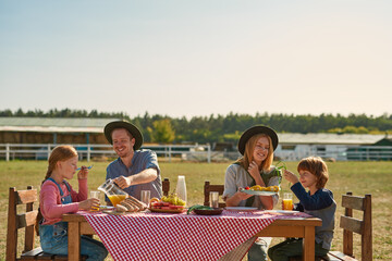 Farming family have lunch in countryside outdoors