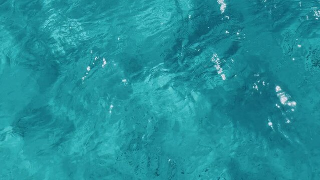 Closeup abstract of surface blue water for background. Blurred abstract for background. Reflection on surface blue water in the sea. Waves of the sea screensaver for your desktop.