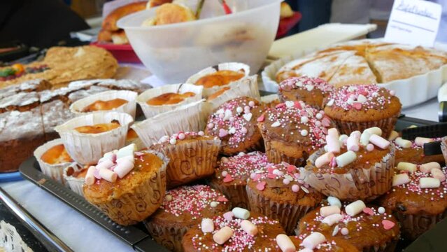 Homemade cakes, freshly baked cupcakes with marshmallow topping on the market stall at the fair
