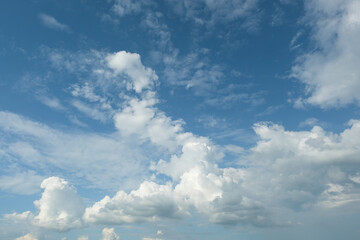 The white clouds have a quaint and rural shape. The sky is cloudy and blue