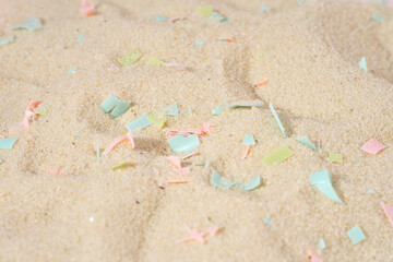 Conceptual composition of microplastics and coastal sand. The concept of environmental damage. The impact of microplastic on nature. The idea of micro plastic pollution. Close-up
