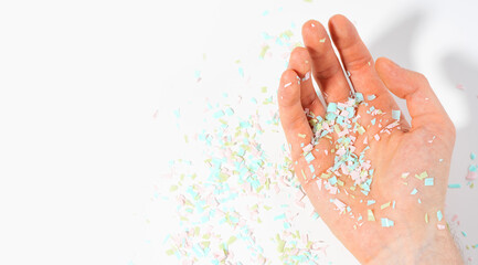 Shot of microplastics lay on people hand. Concept of water pollution and global warming. The idea of environmental damage. White background, top view, copy space