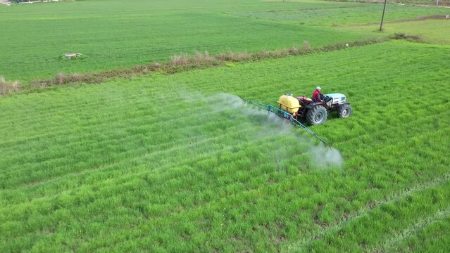 Image of tractor spraying field taken with selective focus.