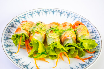 Salmon salad rolls with dipping sauce on white plate .