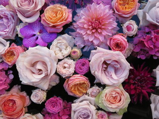 Floral background. Multi-coloured fresh pastel color flowers in the water, top view from above. Natural flat lay. Variety of flowers.