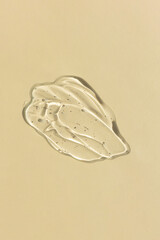 Transparent hyaluronic gel or serum on a beige background. Smear of skincare cosmetics product. Wellness and beauty concept. Top view