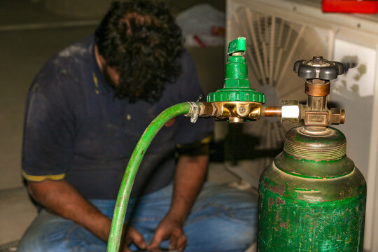 electrician filling gas in air conditioner and repair