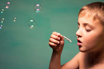 Obraz premium child blows soap bubbles