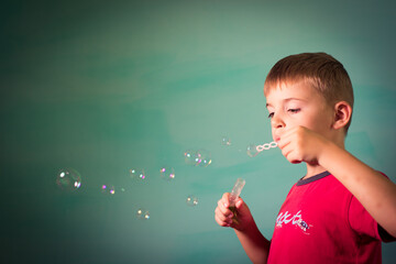 child blows soap bubbles