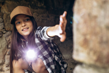 Girl with flashlight in cave searching antiquity - obrazy, fototapety, plakaty