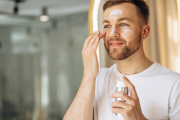 Man applying face cream at home