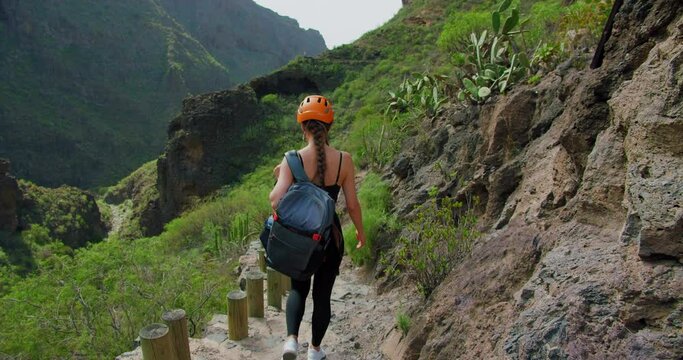 Tourist hiker caucasian girl walks enjoying rocky hiking path. Slow motion. Barranco del Infierno, near to Adeje town. Tenerife.