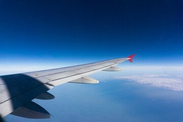 Airplane wing on blue sky cloud window view travel background