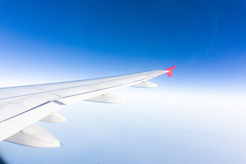 Airplane wing on blue sky cloud window view travel background